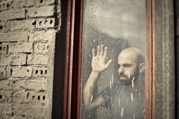 man leaning on window