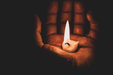 lit candle in hand